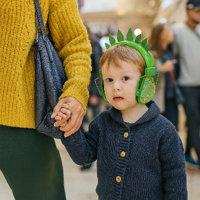 casque anti bruit bebe vert a motif dinosaure porte par enfant dans centre commercial anime