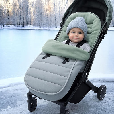 chanceliere poussette grise bebe installe pres lac gele avec arbres enneiges et lumiere hivernale